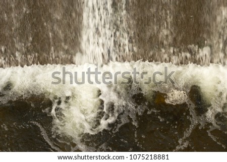water falling from top of dam