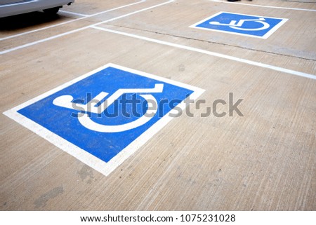 Handicapped sign painted on the floor to reserve parking lot for disabled.