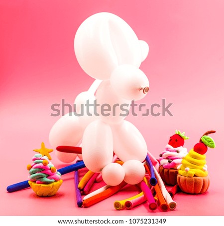 party concept. balloon dog, clay cupcakes and balloons on bright pink background