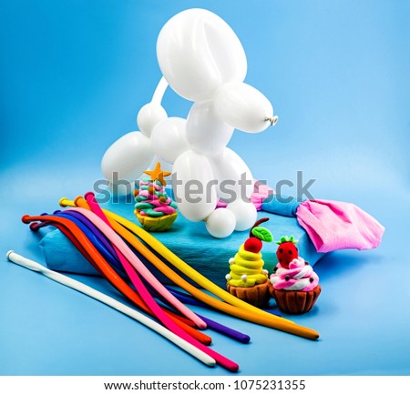 party concept. balloon dog, clay cupcakes and balloons on bright pink background
