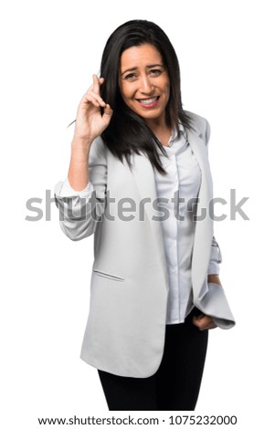 Pretty woman with her fingers crossing on white background