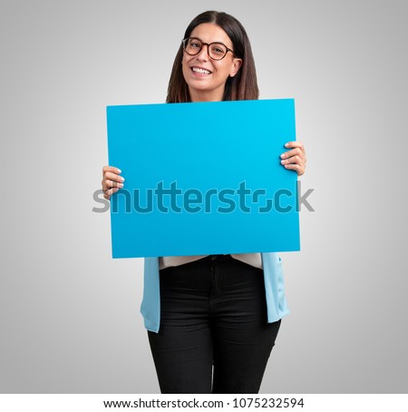 Middle aged woman cheerful and motivated, showing an empty poster where you can show a message, communication concept