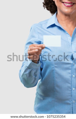 Middle aged woman smiling confident, offering a business card, has a thriving business, copy space to write whatever you want