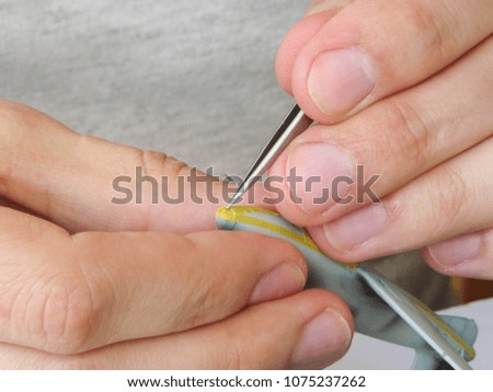 Fingers holding the small details, a man working with small plastic parts, handwork close-up