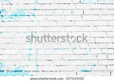 closeup of white brick wall with blue paint stains
