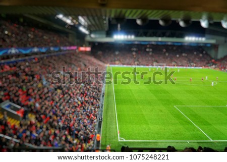 Blurred background of football players playing and soccer fans in match day on beautiful green field with sport light at the stadium.Sports,Athlete,People Concept.Anfield,Liverpool,UK Royalty-Free Stock Photo #1075248221