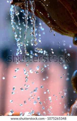 Multicolored water drops in a summer fountain
