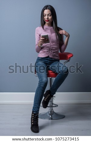 Full length portrait of woman looking smartphone