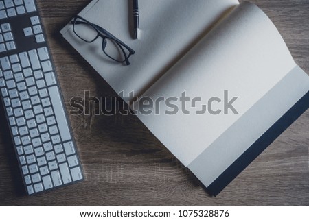 Office working desk table, The business uses keyboard, black notebook ,pen, eyeglasses. Top view background for copy space. Black Desk.