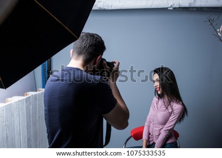 Photographer in studio shot taking beauty wman pictures