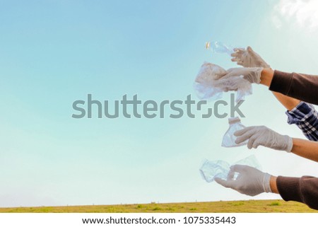 Happy people holding recyclable objects as paper, glass, plastic, on a sky background. Eco concept with recycling.