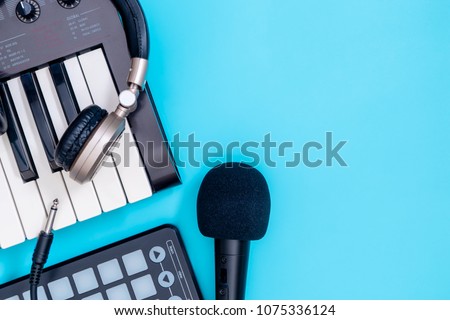 Music recording technology equipment with keyboard headphone and microphone on blue copy space for Home Music Making concept poster and Banner. Royalty-Free Stock Photo #1075336124