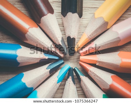 Set of several colored pencils. Pencils in the shape of a circle on a wooden surface