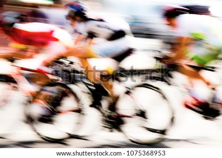Abstract arty background : motion blur of three young bicycle racers competing on city streets
