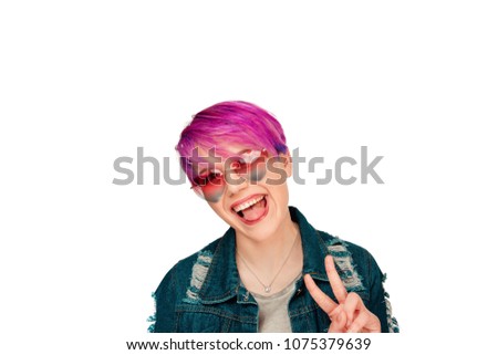 Happy overjoyed beautiful female with magenta short hair, shows cool peace victory sign, says: Yeah, that's wonderful! Pretty young woman gestures indoor against white background. People body language
