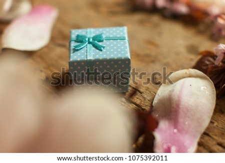 Gift box. Blue gift boxes. Wooden table. Box with blue bow. Bouquet of pink roses on a white background. Minimal composition. Flat lay