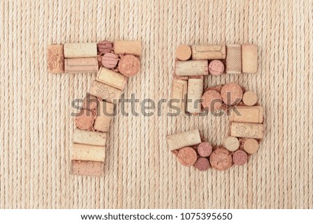 Number seventy five 75 made of wine corks on sea ropes background