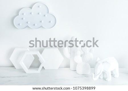 Creative desk with copy space , cacti, elephant figure. White concept of wall with hexagone shapes and cloud.