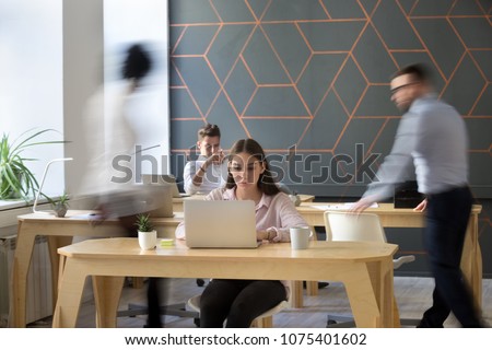 Office rush concept, corporate staff employees working together using computers at coworking, busy focused workers group walking in motion and sitting at desks in modern open space Royalty-Free Stock Photo #1075401602