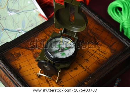 Compass on the map with ropes. Simple navigation tools to orient in the world. Macro