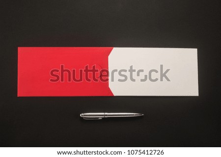 Red envelope with white paper and pen on the table  