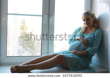 Beautiful girl pregnant blonde prepares to become a mom