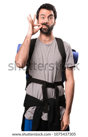 Handsome backpacker making silence gesture on white background