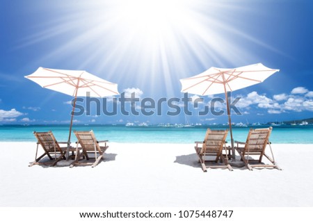Sun umbrellas and beach chairs on tropical beach, Philippines, Boracay Royalty-Free Stock Photo #1075448747