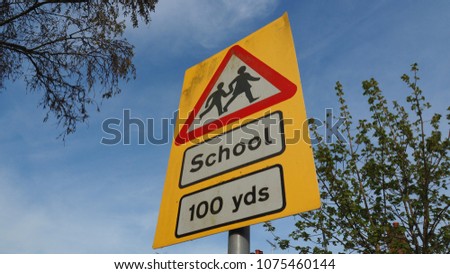 Warming sign on the road to show that School is in distance of 100 yards. Please drive carefully and slow down.