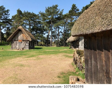 Anglo Saxon huts at west stow in the sunshine Royalty-Free Stock Photo #1075483598