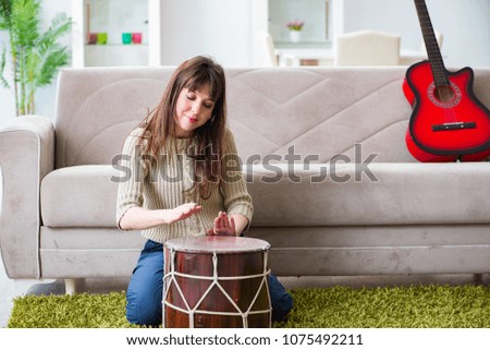 Woman playing drums at home
