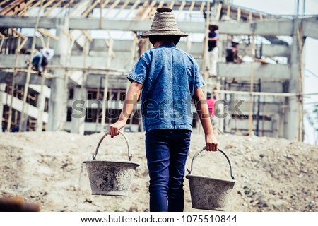 Little girl labor working in commercial building structure, World Day Against Child Labour concept. Royalty-Free Stock Photo #1075510844