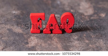 Frequently asked questions abbreviation or FAQ word on old wooden table top