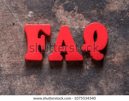 Frequently asked questions abbreviation or FAQ word on old wooden table top