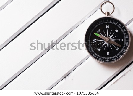Magnetic compass on wooden table top

