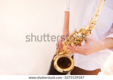 selective soft focus.hands saxophonist playing saxophone on white wall background .concept for instrument musician,world Jazz festival,musical background.copy space for text