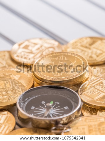 Magnetic compass with arrow pointing to bitcoin. Conceptual image.