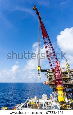 Offshore crane on a construction barge while on lifting operation at oil field