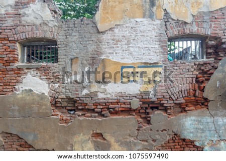 exterior view of housing board apartment seen with red bricks and collapsed walls. 
