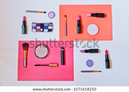 Makeup cosmetics and brushes on colorful paper background