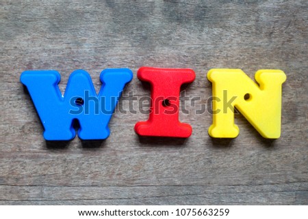 Color alphabet in word win on wood background