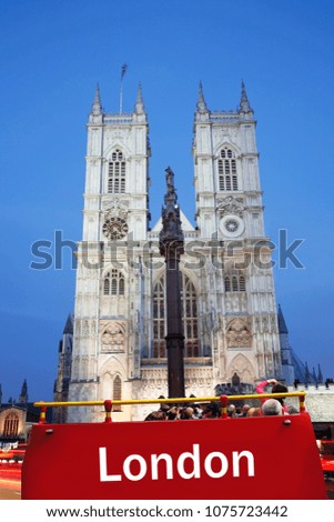 Tourists on a London Open-Top City Tour Bus enjoying London sightseeing. Westminster Abbey present.