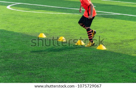 Soccer Football Training Session for Kid. Asian Boy Training Football on the Pitch.  