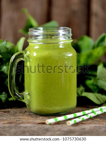 Healthy smoothies in mason jar from spinach, cucumber, celery, apple, parsley with olive oil