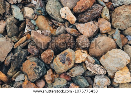colorful Many Pebbles stone Big and small for texture background. The rocks flow from the river in the mountains of the tropical forest. In the summer less water rocks will emerge at the beach.