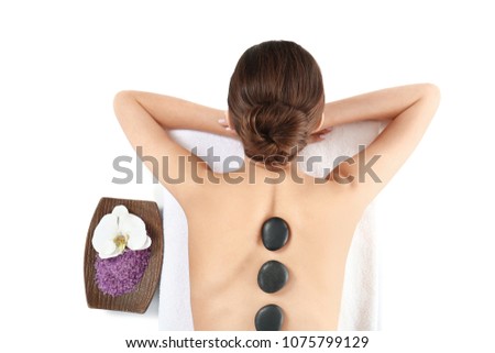 Young woman enjoying stone massage on white background. Spa treatment