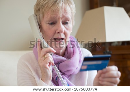 Senior Woman Giving Credit Card Details On The Phone Royalty-Free Stock Photo #1075803794