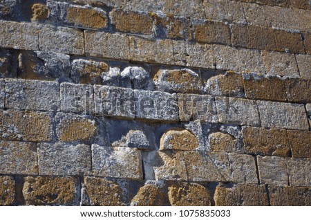 Wall in local stone, of tufa and crumbled plaster, in Orvieto