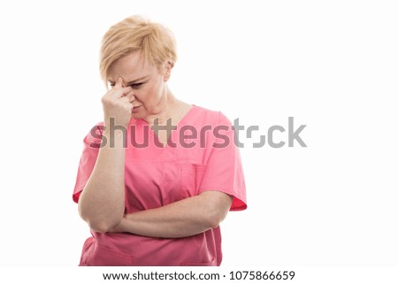 Female nurse wearing pink scrubs standing and concentrating isolated on white background with copyspace advertising area