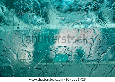 Car window closeup being washed in car washer machine